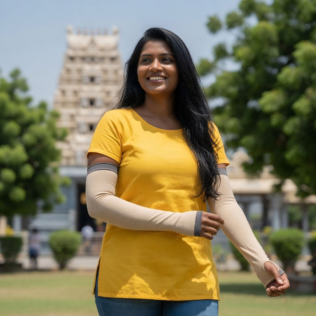 Woman in a yellow shirt with arm sleeves standing outdoors with a temple in the background